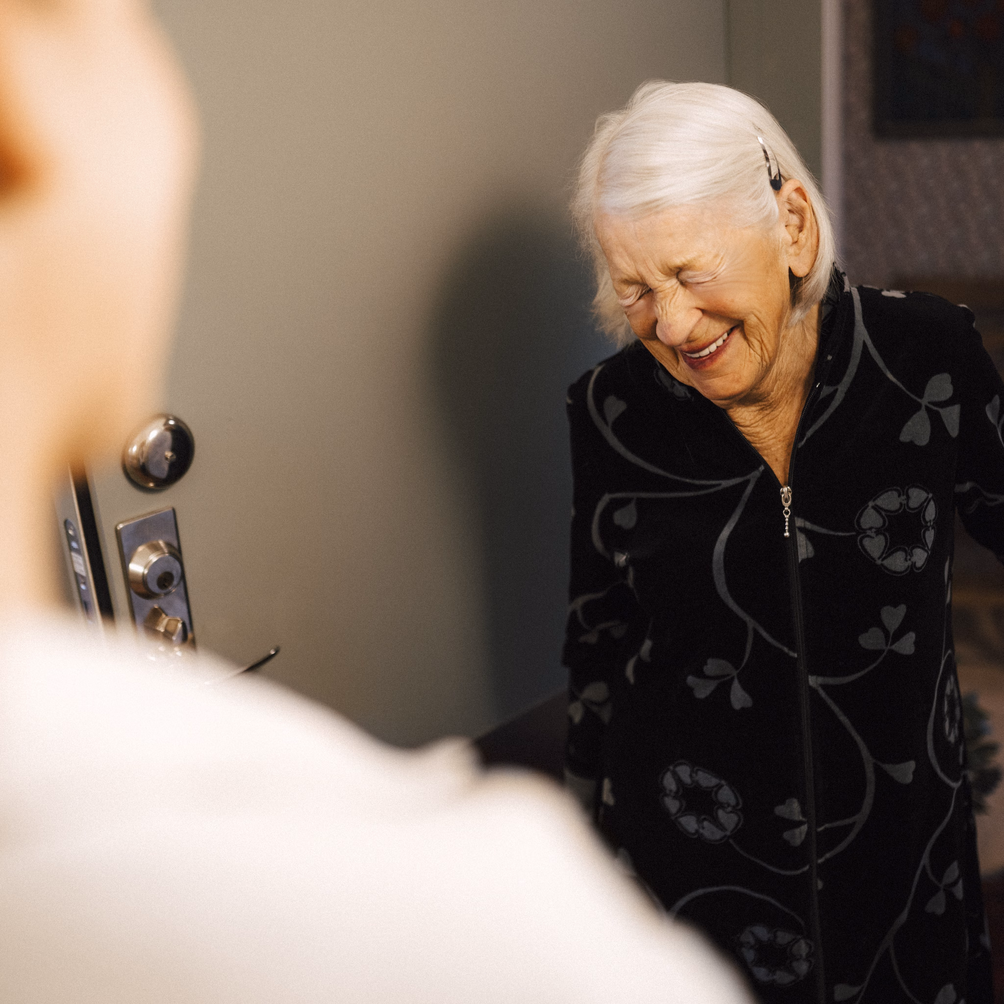 Seniorin steht vor einer jüngeren Frau und freut sich 