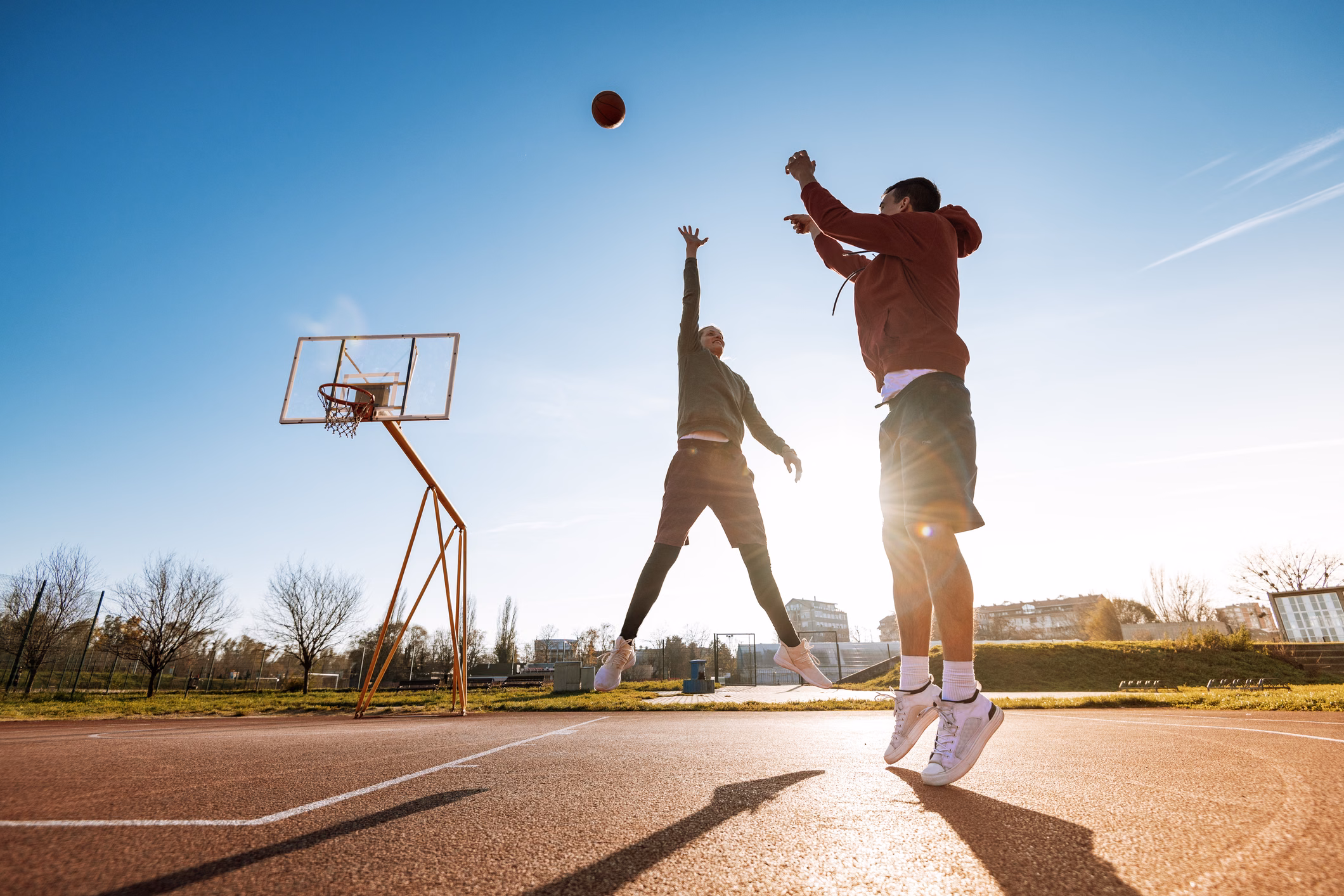Mann und Frau spielen draußen Basketball